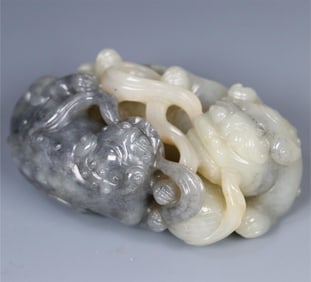 A Qing Dynasty Hetian jade blue and white seed material double lion play hydrangea ornament
