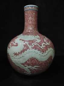 A glazed red carved seawater carved white glazed dragon pattern celestial ball vase made in the