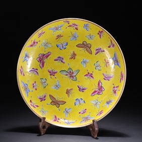 A yellow glazed pastel hundred butterfly plate from the Qing Dynasty
