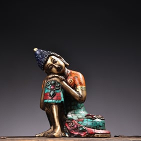 A statue of Shakyamuni sleeping Buddha with jewels painted in gold and gold
