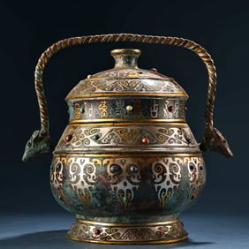 A bronze piece of gold and silver inlaid with gemstones