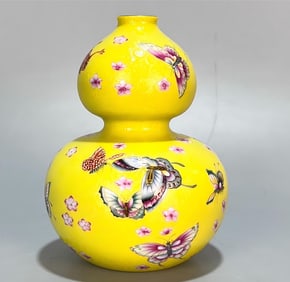 A Qing Dynasty Yongzheng year enamel lemon yellow ground peeled flower and gourd saucer gourd bottle