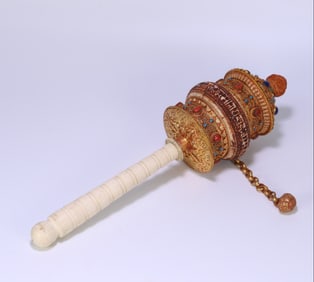 A fine silver-gilt filigree set with gemstones and a prayer wheel