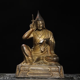 A bronze gold statue of the Guru Buddha