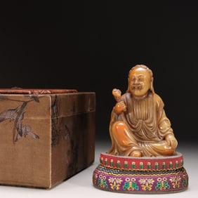 A seated statue of a Qing jade spun Shoushan field yellow stone carved Arhat
