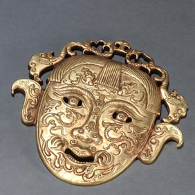 A copper-gilt masked man
