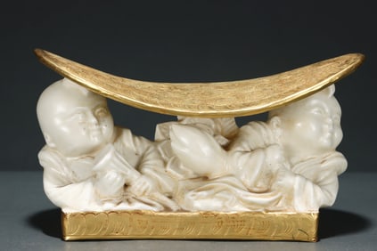 A Song Dynasty Ding kiln wrapped gold carved entwined bat pattern boy porcelain pillow