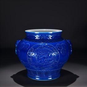 A Qing Qianlong peacock green glaze carved phoenix pattern animal head jar