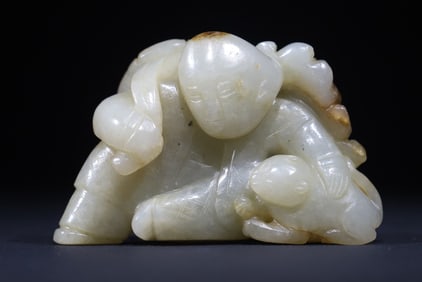 A Qing Dynasty jade carving boy holding Lianya to play