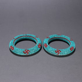 A pair of turquoise wrapped rice beads swastika bracelets