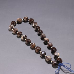 A Tibetan old agate bead is held