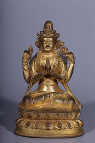A seated statue of Guanyin with four arms in copper gilt in the Qing Dynasty