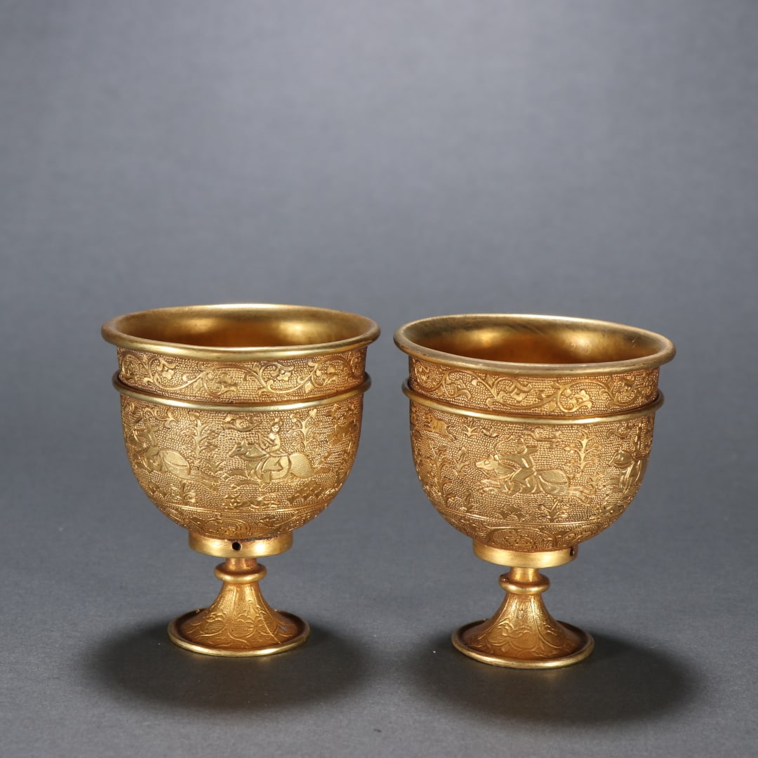 A pair of Tang silver gilt hunting picture wine glasses: Tang A pair of silver gilt hunting picture wine glasses SIZE: H: 6.2cm W: 5.3cm Total W: 210.2g (The Dimensions Of All Batches Are Manually Measured.If You Need More Detailed Information, Please Conta