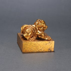 A copper gilt beast button seal