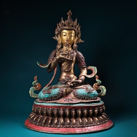 A Buddha statue carved with gemstones painted with gold painting