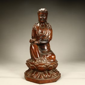 A seated statue of Guanyin holding a sutra in agarwood in the Qing Dynasty