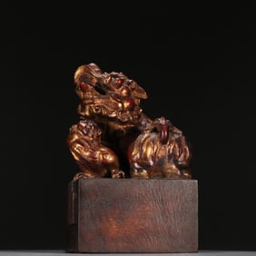 A Qing Dynasty agarwood gold-painted mother beast button seal
