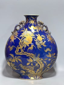 A Qing Dynasty Qianlong year Ji blue glaze gold-painted nine peaches double ear moon vase