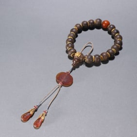 A piece of agarwood inlaid with silver gilt eighteen hands