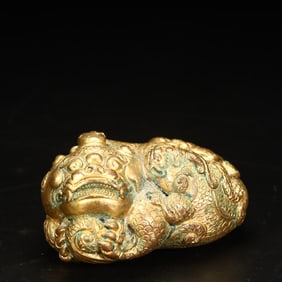 A Qing Dynasty copper-gilt auspicious beast paperweight