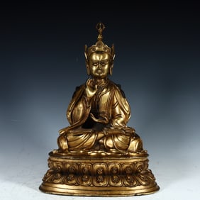 A Qing Dynasty copper gilt lotus peanut master statue