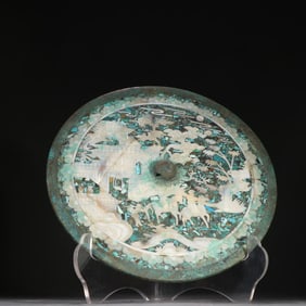 A bronze mirror inlaid with turquoise and spiral characters