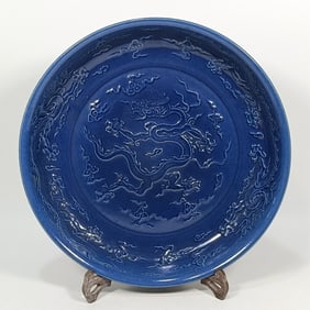 A Ming Dynasty blue glaze carved dragon pattern plate