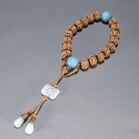 A Qing Dynasty agarwood inlaid silver gilt longevity pattern held by the eighteenth son