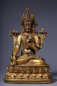 A seated statue of Guanyin with a bronze gilt inlaid treasure holding lotus in the Qing Dynasty