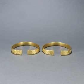A pair of copper-gilt bracelets