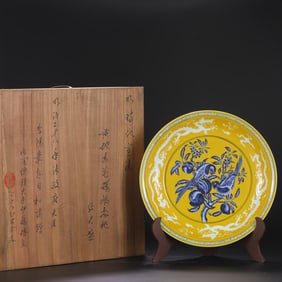 A Ming Dynasty Xuande yellow ground blue and white parrot longevity peach pattern plate