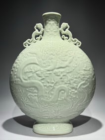 A Qing Dynasty Qianlong bean celadon carved Canglong godson binaural moon bottle