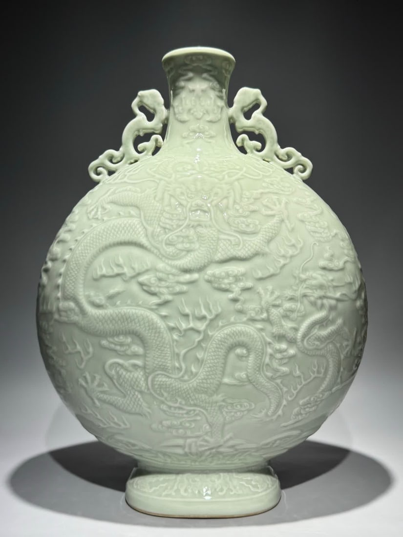 A Qing Dynasty Qianlong bean celadon carved Canglong godson binaural moon bottle: Qing Dynasty Qianlong bean celadon carving Canglong godson double-eared moon bottle SIZE: H:48.8cm W:35cm (The Dimensions Of All Batches Are Manually Measured.If You Need More Detailed Information, Pl