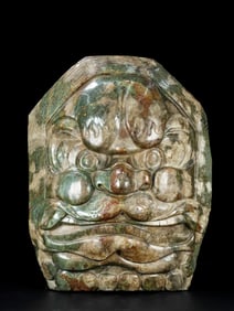A shield with the face of an ancient jade beast