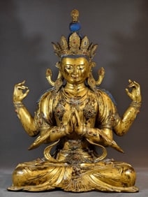 A Qing Dynasty copper-gilt four-armed Guanyin