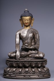 A seated statue of the Buddha with a gold face in copper gilt and silver clay in the Qing Dynasty