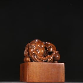 A piece of sandalwood peace has an elephant button seal