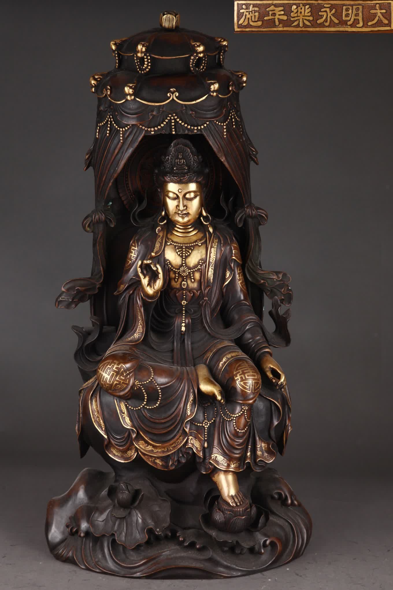 A seated statue of Guanyin in the Ming Dynasty with a fine cast copper tire gilt canopy