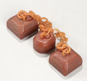 A Qing Dynasty red field yellow stone carving triptych