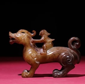 A Han Dynasty feathered man riding a beast ornament