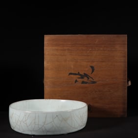 A Song Dynasty official kiln moon white glaze pile carved dragon pattern round wash