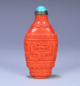 A Qing Dynasty coral-colored glazed snuff bottle