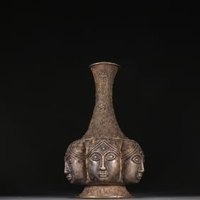 A copper Buddha head lamp vase