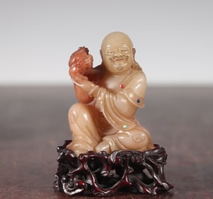 A Qing Dynasty Shoushan stone inlaid with a statue of a treasured Arhat