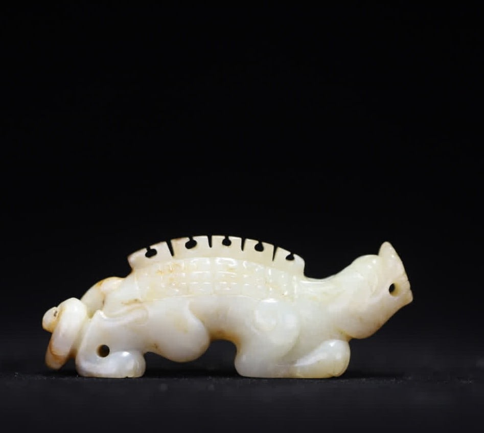 A piece of Hetian jade auspicious beast handle: The Hetian jade auspicious beast handle is carved into the shape of an auspicious beast with warm Hetian jade as a material, the beast body is curled and flexible, the back is decorated with scales