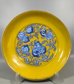 A blue and white plate with a yellow background in the Qing Dynasty