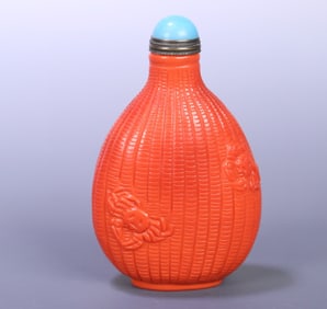 A coral-colored glass snuffbox