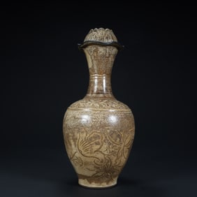 A Qing Dynasty Cizhou kiln carved lotus petal mouth bottle