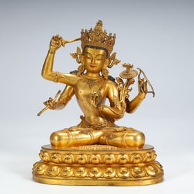 A seated statue of Manjushri Bodhisattva with four arms in copper gilt inlaid with treasures in the