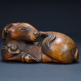 A Qing Dynasty boxwood carved lying sheep paperweight